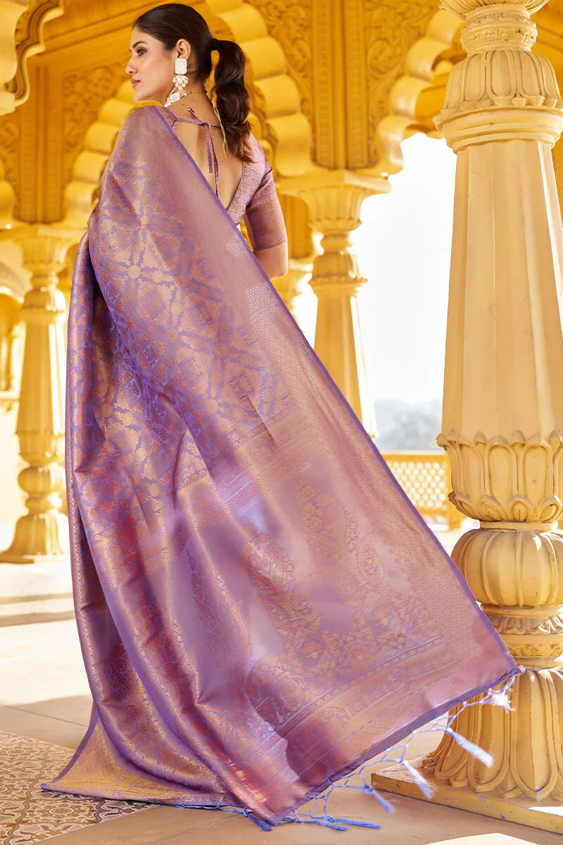 Woman wearing a purple saree with a gold background
