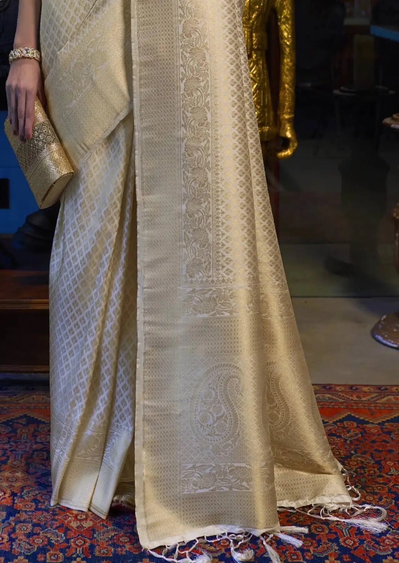 Beige saree with intricate patterns on a patterned floor