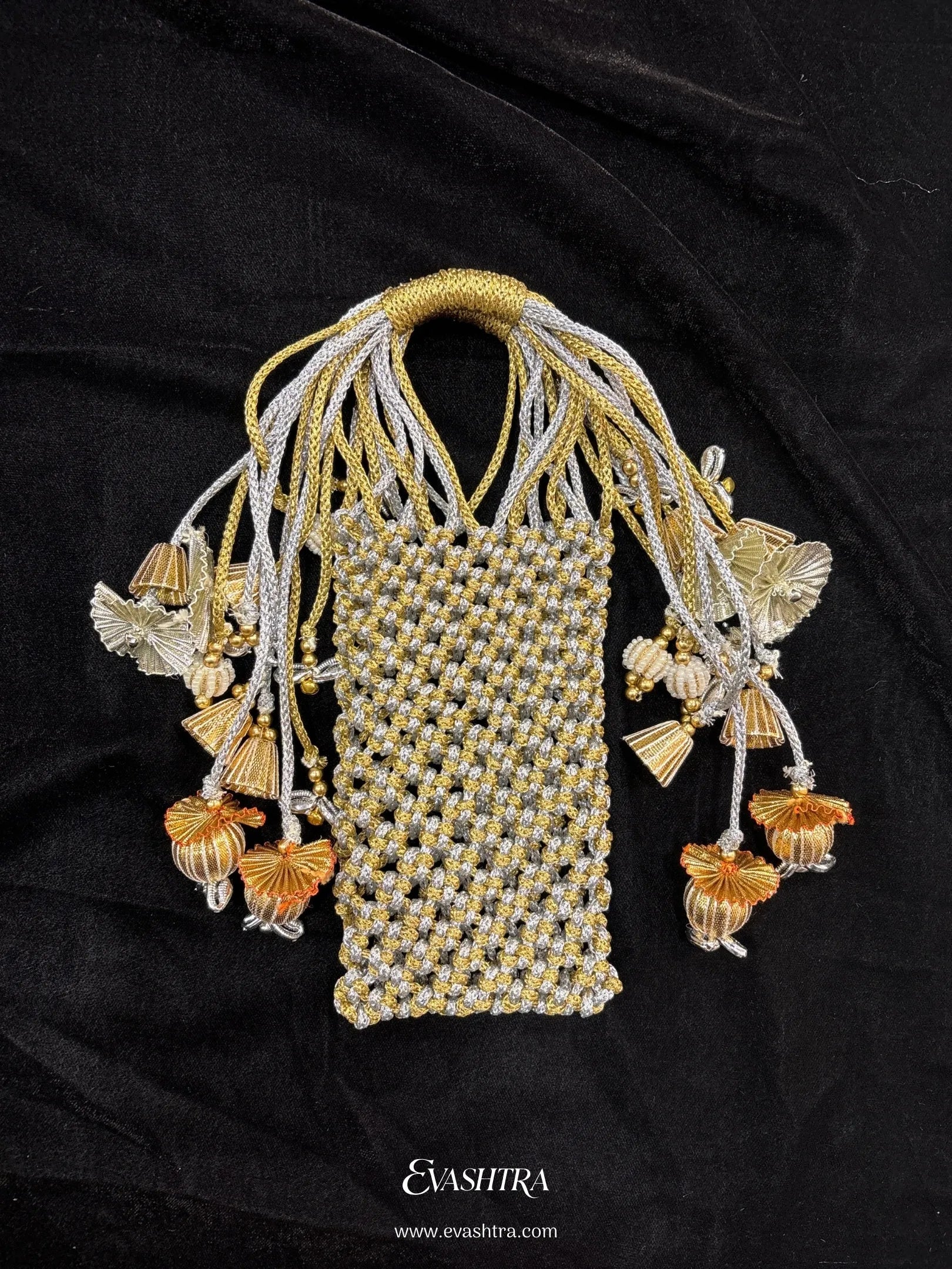 Decorative gold and silver beaded pouch with tassels on a black background, branded 'Evasitra'.