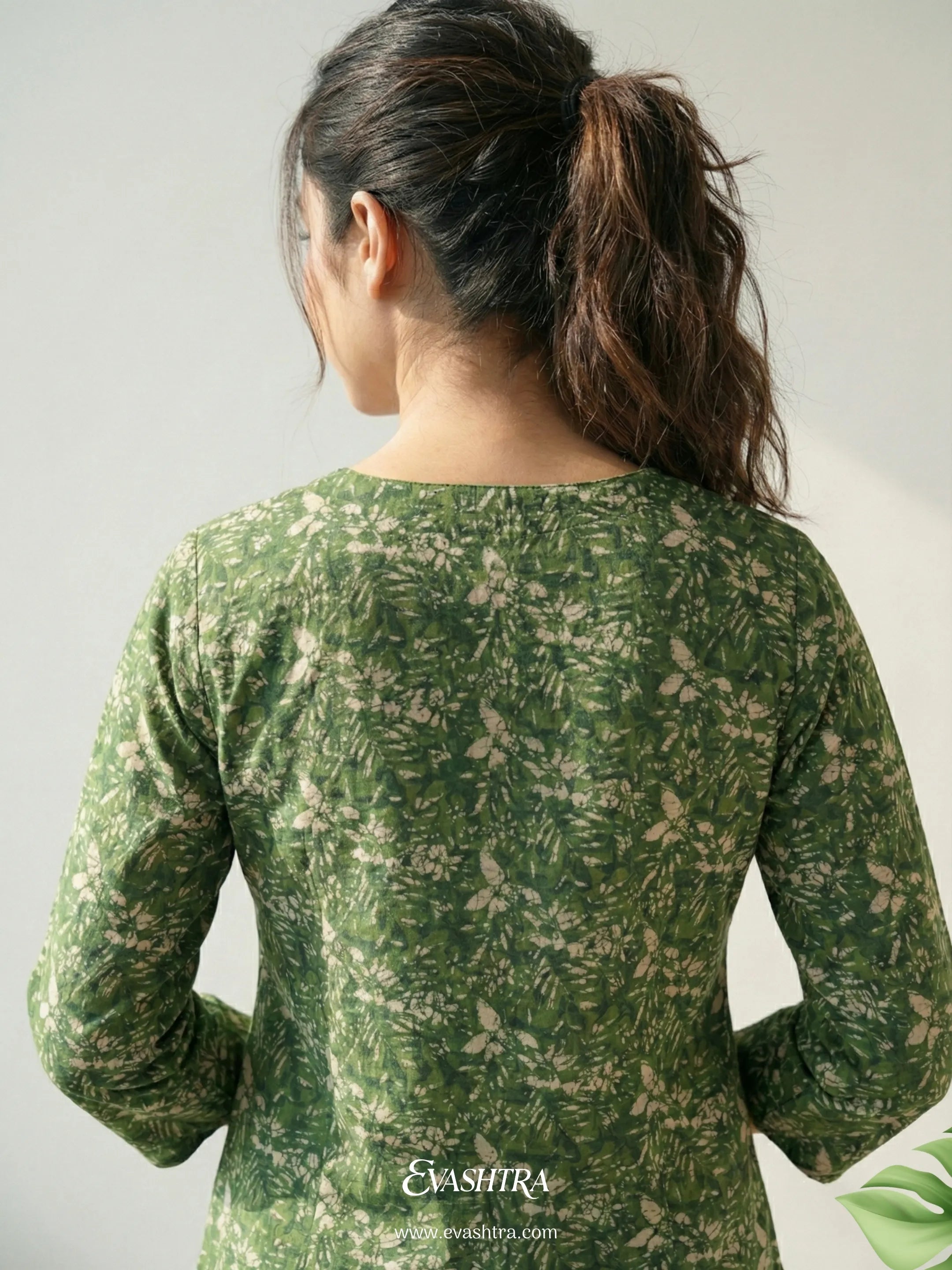 Person wearing a green floral patterned shirt with 'EvaShirt' branding.