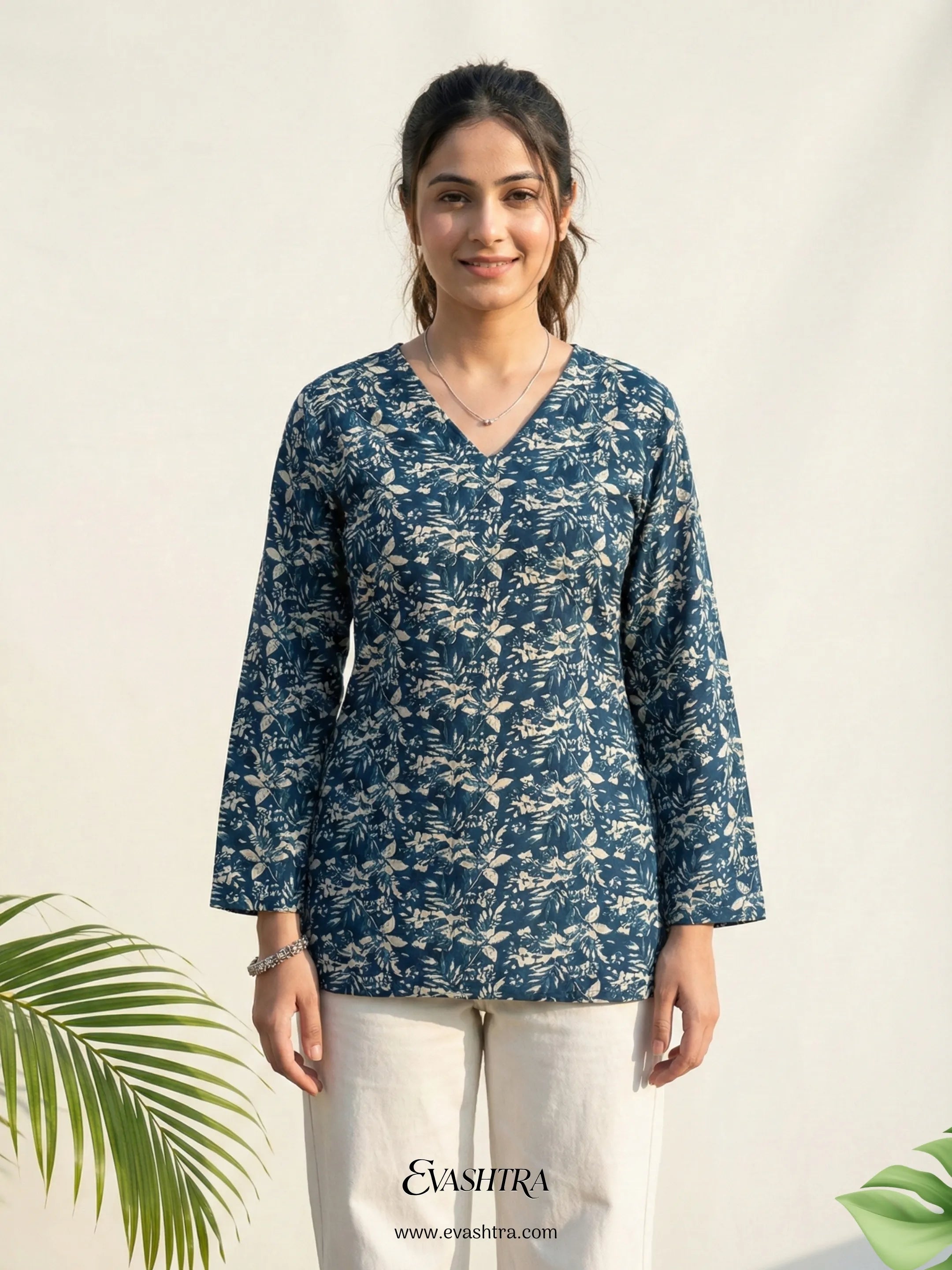 Woman wearing a blue floral patterned top with a white background