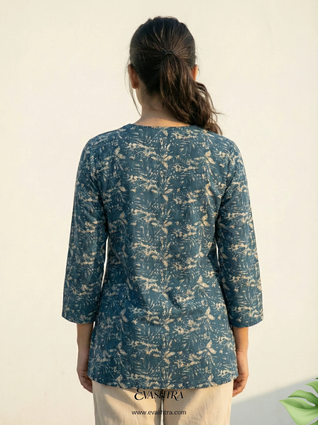 Woman wearing a blue patterned top on a beige background