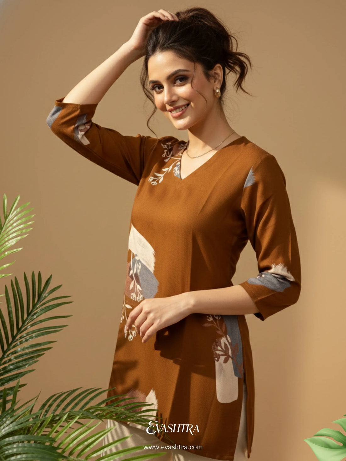 Woman wearing a brown outfit with floral patterns, standing against a beige background with green leaves.