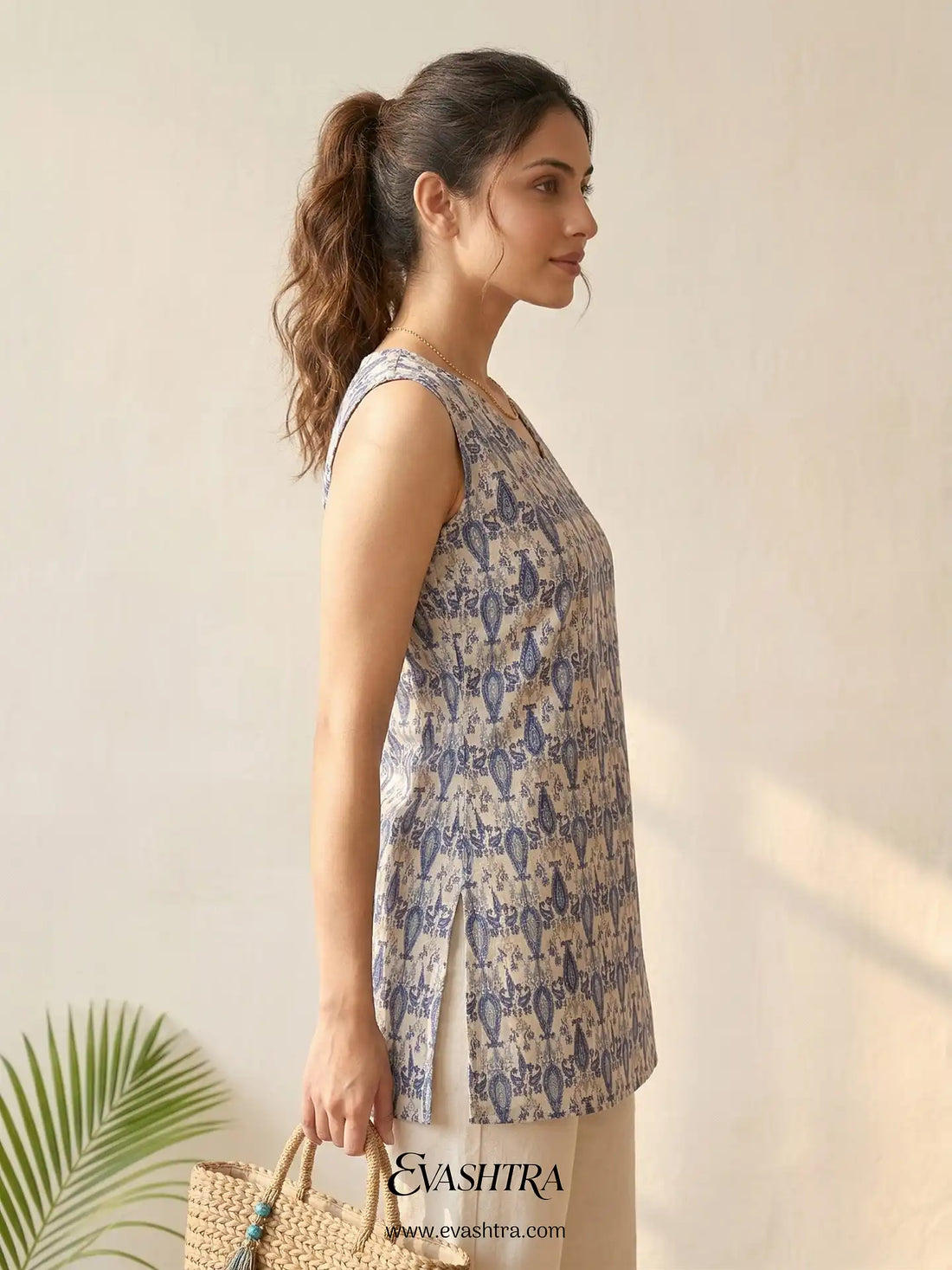 Woman wearing a patterned top with a plain background, featuring the brand 'Evashree'.