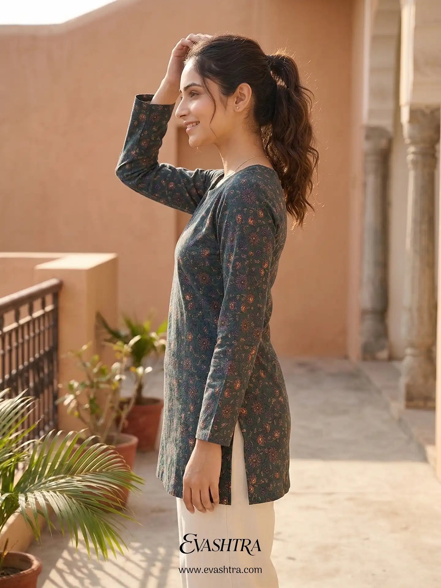 Woman wearing a floral long-sleeve top with 'EvaShra' branding in an outdoor setting.