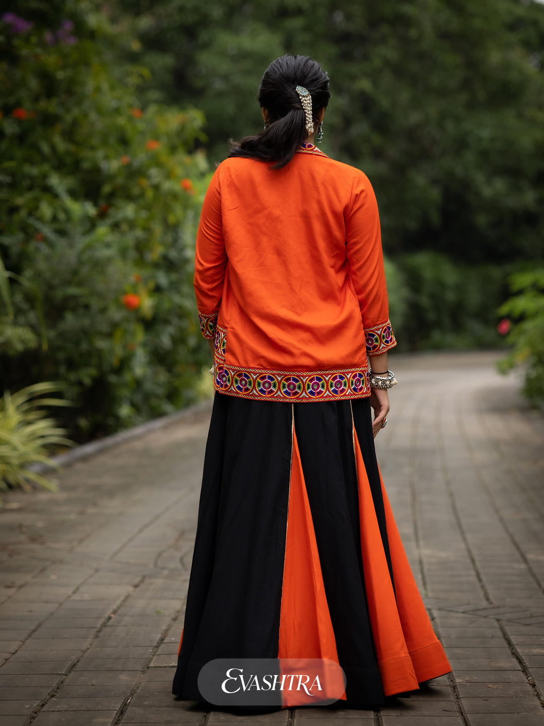 Woman in traditional black and orange outfit