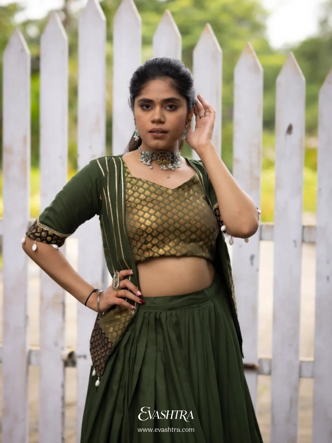 Woman wearing a green traditional outfit with a white picket fence 4