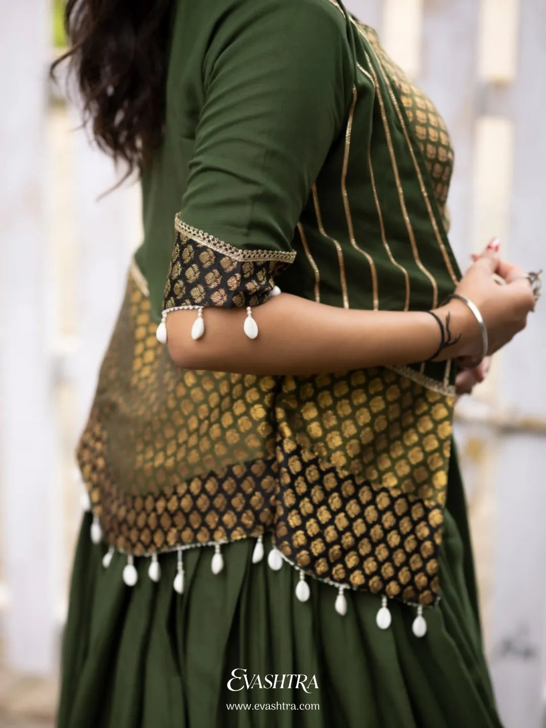Woman wearing a green traditional outfit with a white picket fence 5