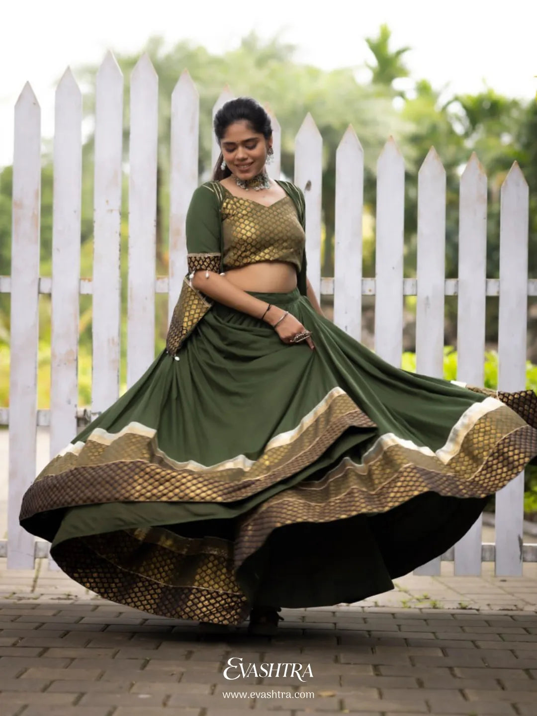 Woman wearing a green traditional outfit with a white picket fence 6