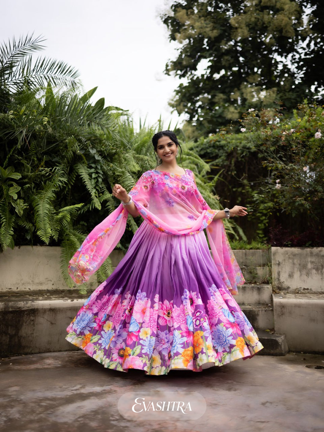 Front view of woman wearing Blossom Cascade printed lehenga in orchid pink with floral and geometric design, paired with matching dupatta.
