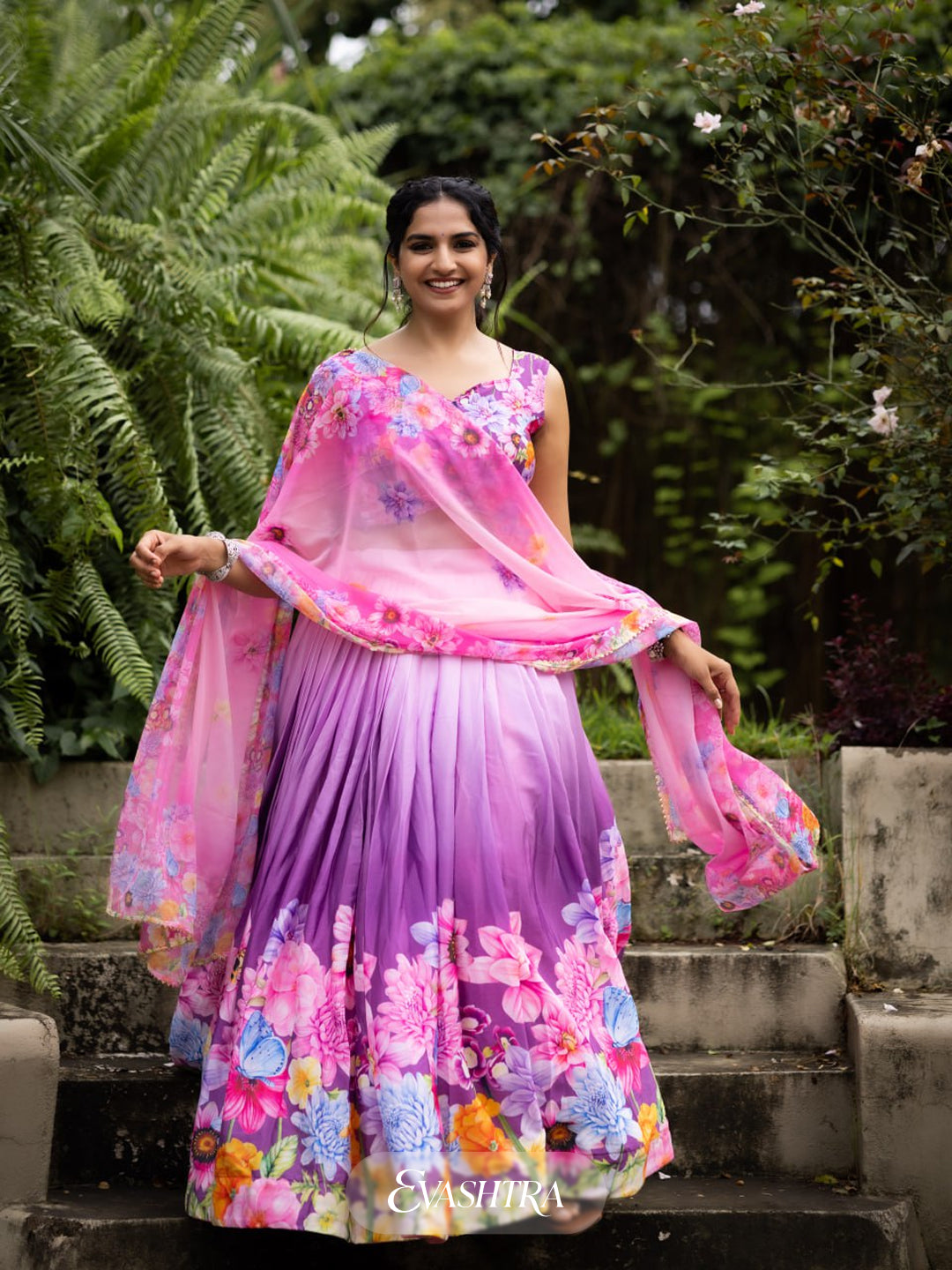 Front view of woman wearing Blossom Cascade printed lehenga in orchid pink with floral and geometric design, paired with matching dupatta.