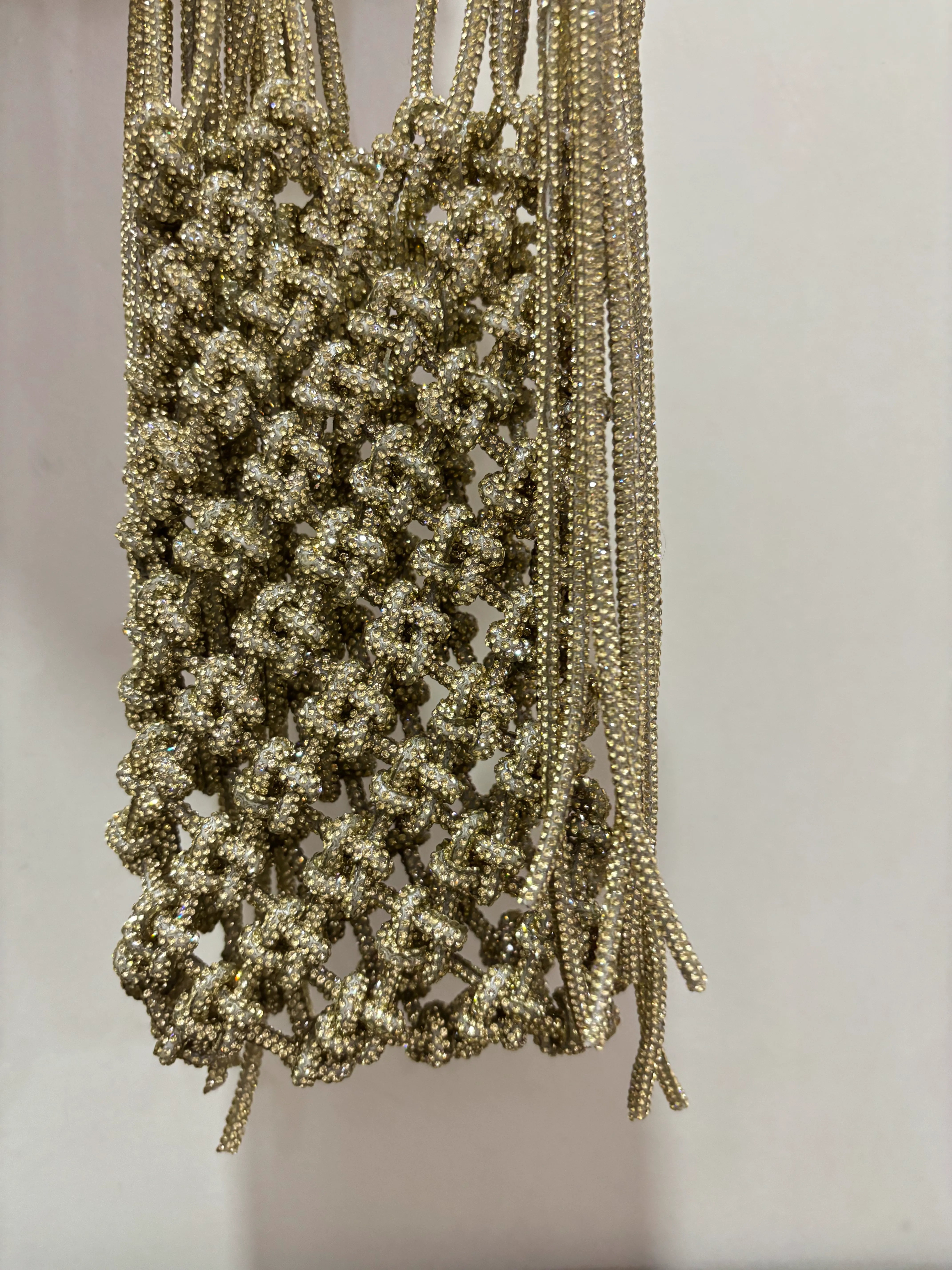 Gold beaded necklace on a plain background
