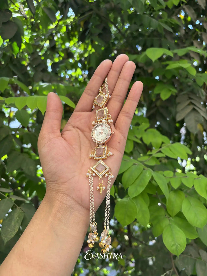 Decorative bracelet with a watch held in a hand against a green leafy background
