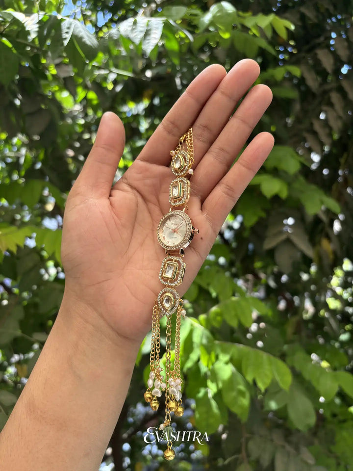 Hand holding a decorative bracelet with a green leafy background
