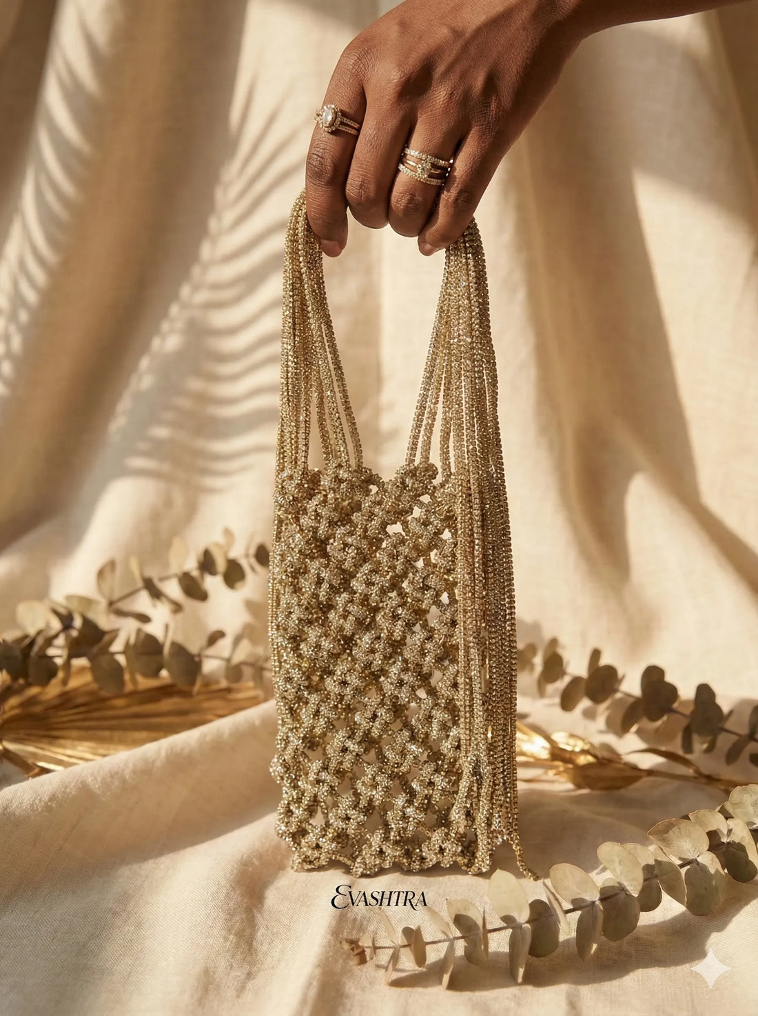Hand holding a beaded handbag with a neutral background